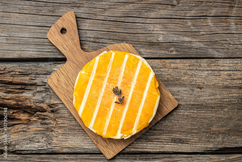 cream Round brie or camambert cheese on a wooden board. Rougette cheese on a wooden background, banner, menu, recipe place for text, top view