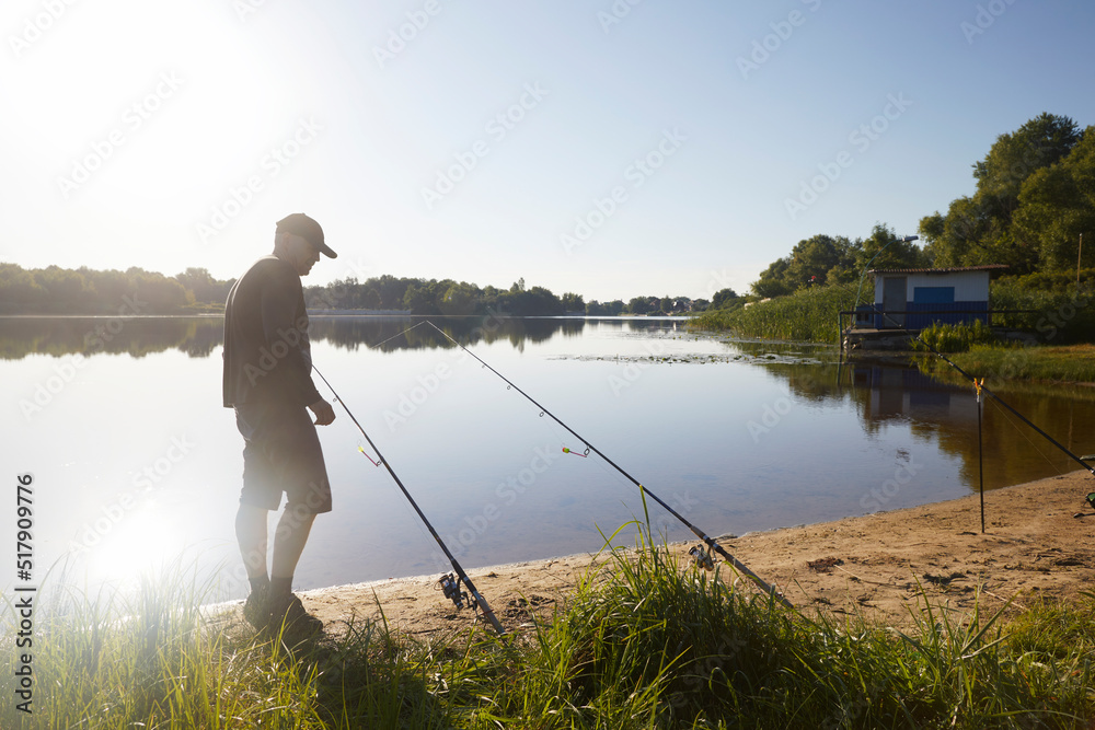 Caucasian adult man fishing on the river with beautiful view of landscape.
