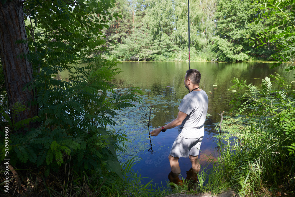 Caucasian adult man fishing on the river with beautiful view of landscape. Caucasian adult man fishing on the river with beautiful view of landscape.