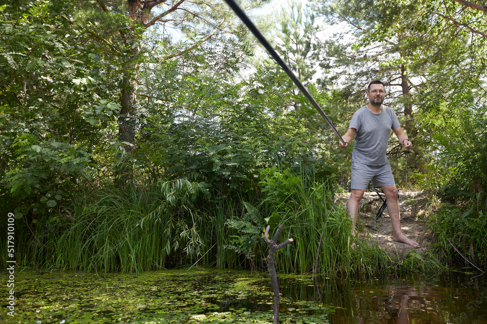 Caucasian adult man fishing on the river with beautiful view of landscape. Caucasian adult man fishing on the river with beautiful view of landscape.