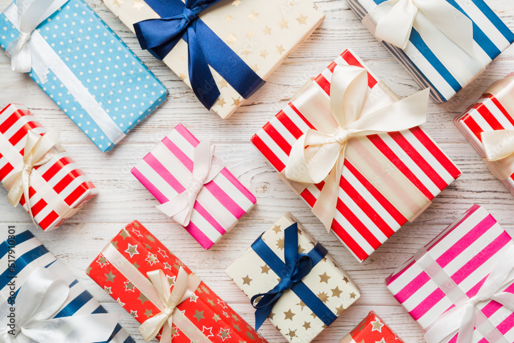 Fototapeta premium A lot of Christmas gift boxes in colored paper decorated on table, Top view close up. Many present New Year gift