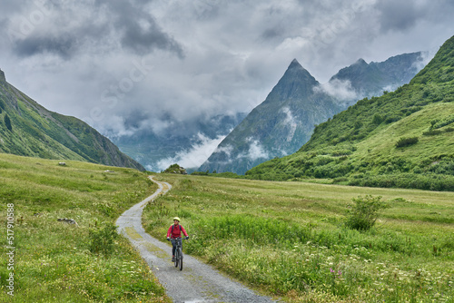 nice active senior woman riding her electric mountain bike in the silvretta mountain range near Gaschurn, Tyrol, Austria