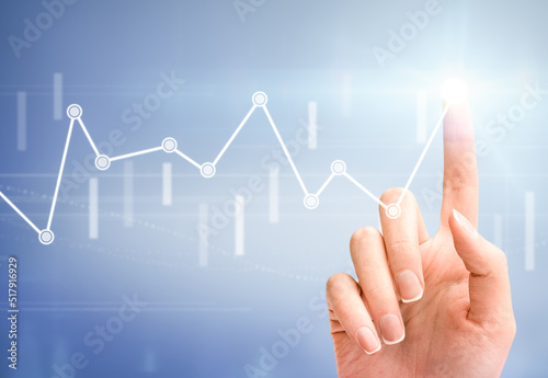 female hand touches a virtual financial graph on a light blue background