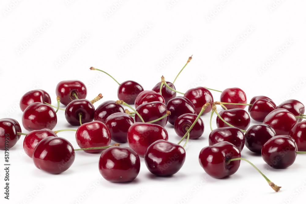 A lot of ripe cherries scattered on bright background. Close up view. A lot of ripe cherries scattered on bright background. Close up view.