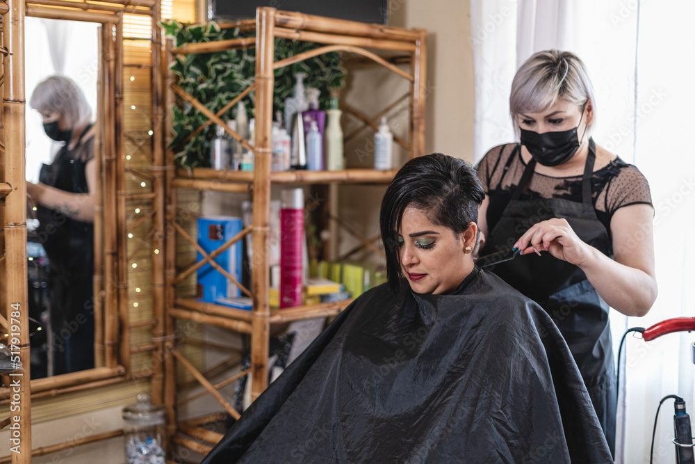 Horizontal of a hairdresser cutting her client's hair in her salon. 