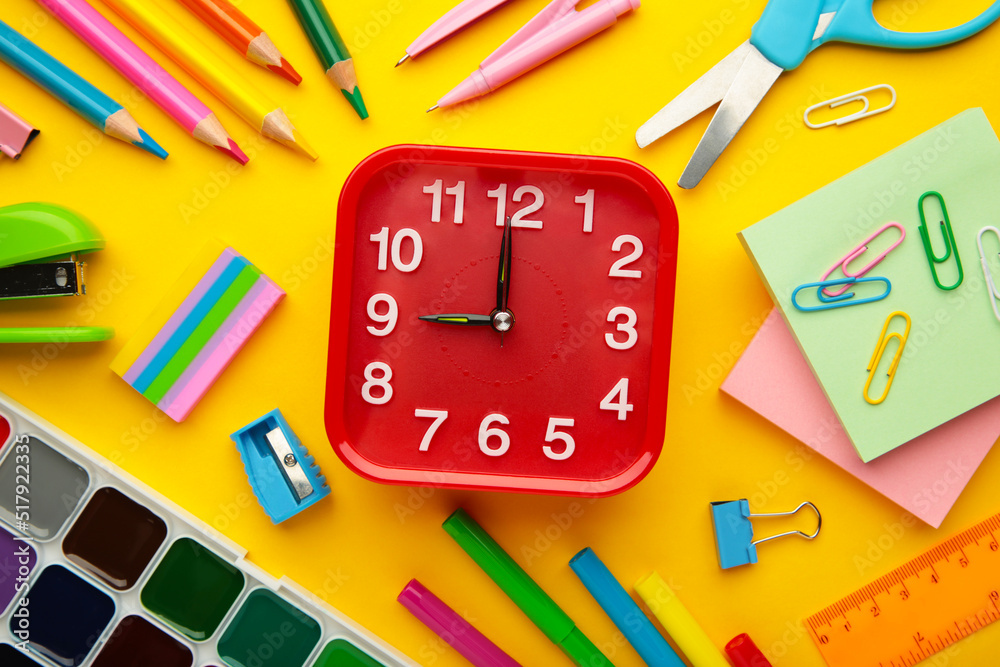 Alarm clock, paint, pencils and scissors. School accessories on a yellow background. Back to school concept. Alarm clock, paint, pencils and scissors. School accessories on a yellow background. Back to school concept.