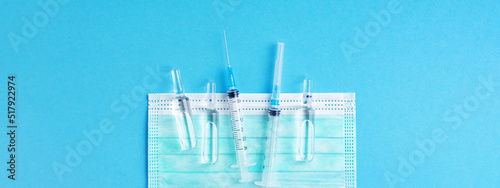 Medical banner for website with injection, vaccination medications and syringes on blue background.