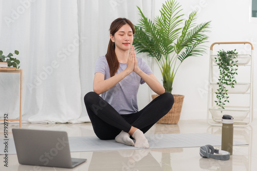 Free Download Yoga exercise concept, Young Asian woman in lotus position while doing yoga exercise online at home - GFXLoad