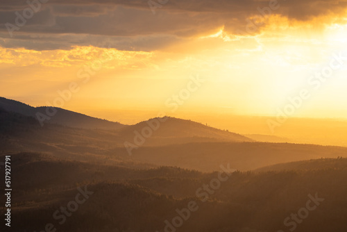 The sun shines over a mountain range in the northern Black Forest during the golden hour