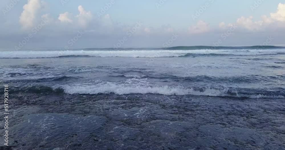 drone shot of high white foaming waves arriving at a sandy beach drone shot of high white foaming waves arriving at a sandy beach