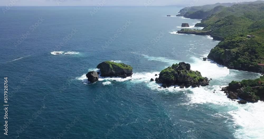 birds eye view of the white foaming waves breaking on the rocky coastline of timang island indonesia birds eye view of the white foaming waves breaking on the rocky coastline of timang island indonesia