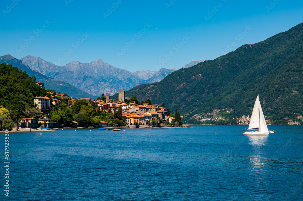 The town of Santa Maria Rezzonico, on Lake Como, photographed on a summer day, with its tower and the Alps in the background.
