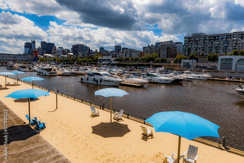 Artificial sandy beach on the bank of St. Laurence river in Montreal Old Port, summer season in Montreal, Quebec, Canada © Natalia