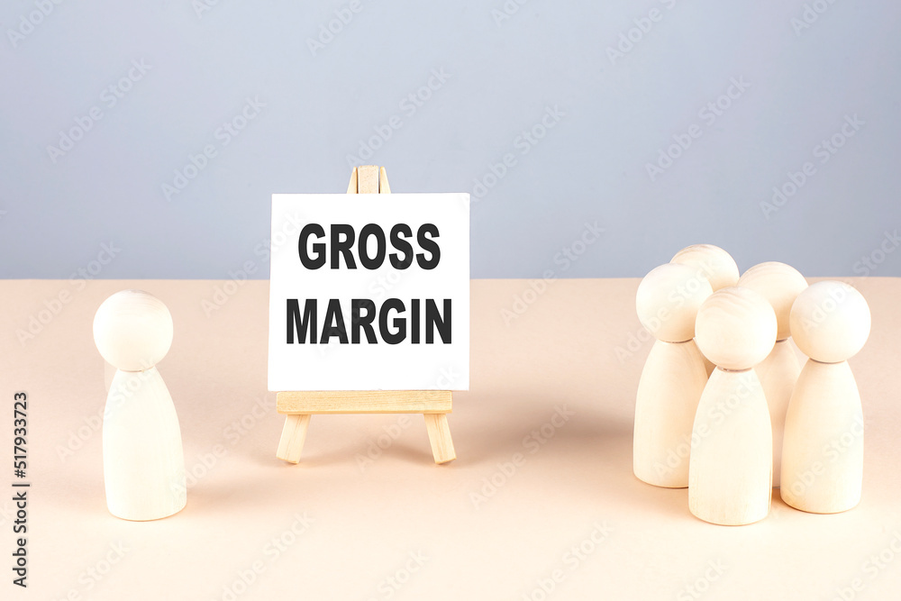 GROSS MARGIN text on easel with wooden figure, meeting concept GROSS MARGIN text on easel with wooden figure, meeting concept