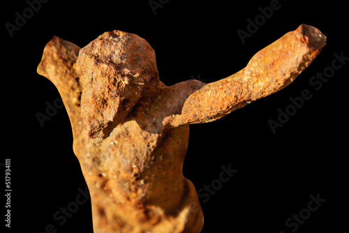 Very ancient destroyed iron statue of crucifixion of Jesus Christ. Isolated on black background.
