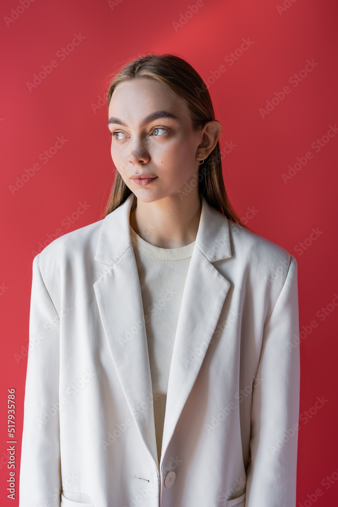 charming woman in white oversize blazer looking away isolated on crimson. charming woman in white oversize blazer looking away isolated on crimson.