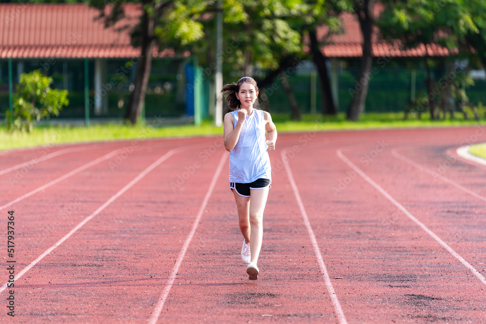 Asian women are jogging in the morning at the stadium to keep fit and healthy.