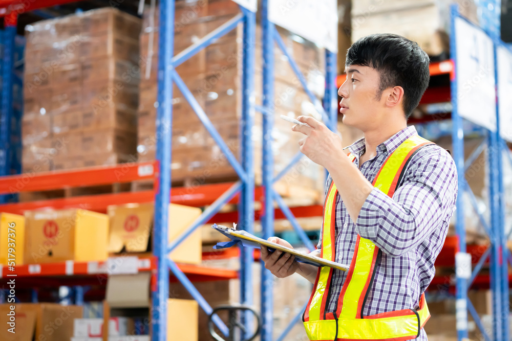 A man in charge of a large warehouse is checking the number of items in the warehouse that he is responsible for. A man in charge of a large warehouse is checking the number of items in the warehouse that he is responsible for.
