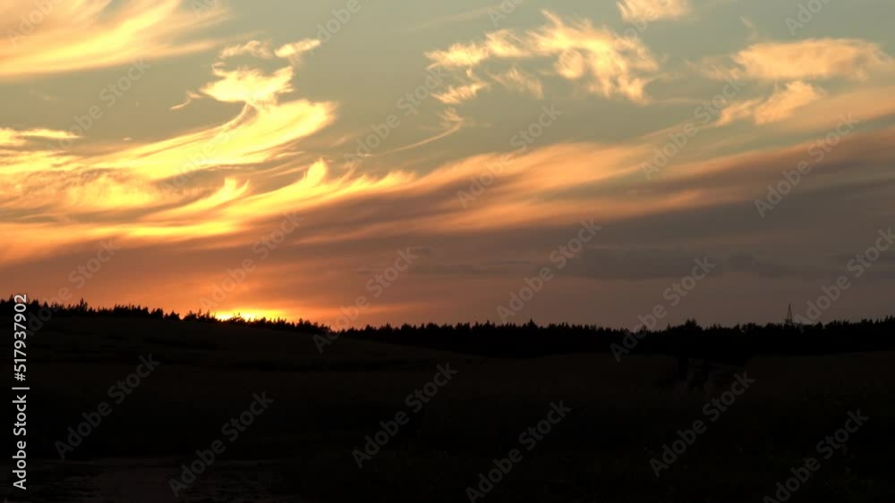 Bright multi-colored clouds are in the sky just after sunset.