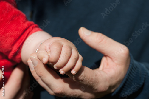 father holding baby's hand