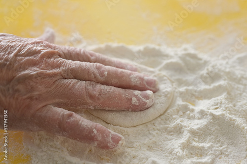 grandmother's hand close-up. Elderly woman cooks pies in the kitchen