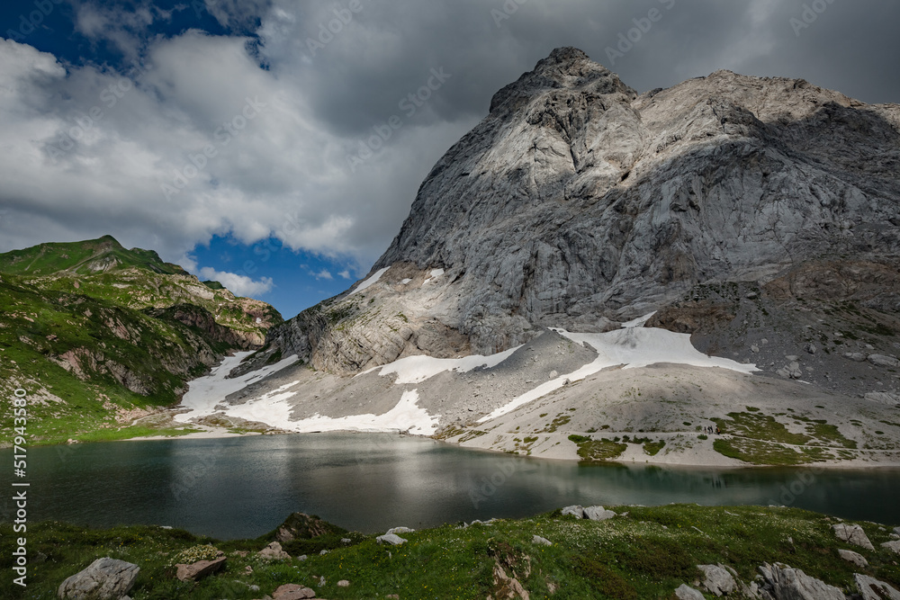 Between Italy and Austria: mountain hiking Trail Road near Volaia Lake Raunchkofer Mountain (Lago di Volaia Monte). Grey sky before thunderstorm background.