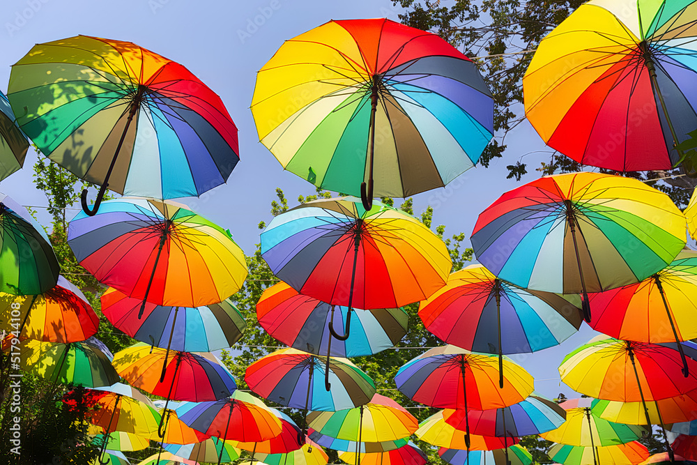 Multicolored umbrellas hanging above street in Istanbul in sunny day and blue sky