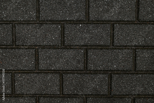 Rough textured surface of gray rectangular paving slabs, close up.