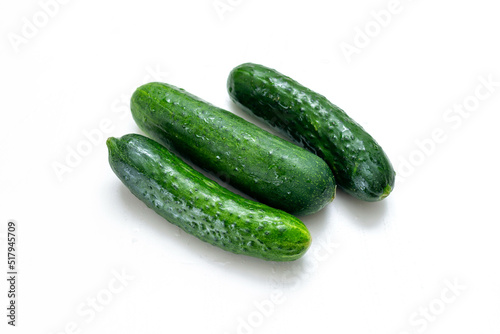 three fresh cucumbers on a white background