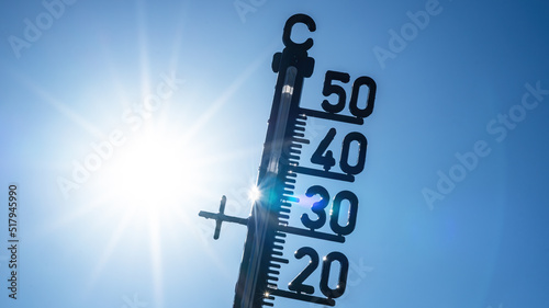 Hot weather - Heat wave / Summer heat background - Thermometer blue sky and sun rays