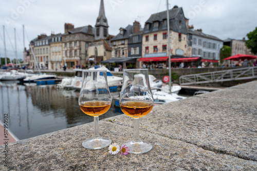 Tasting of apple calvados drink in old Honfleur harbour with boats and old houses on background, Normandy, France © barmalini