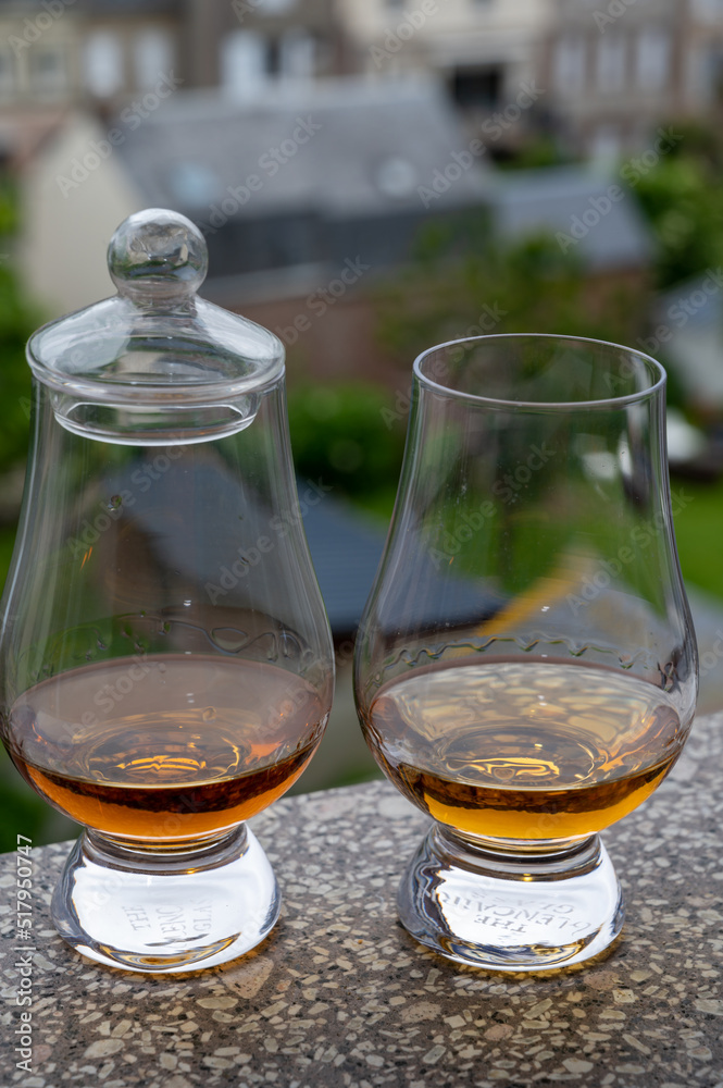 Two glasses of scotch whiskey with view on old houses on background, Edinburgh whisky tasting tour, Scotland Two glasses of scotch whiskey with view on old houses on background, Edinburgh whisky tasting tour, Scotland