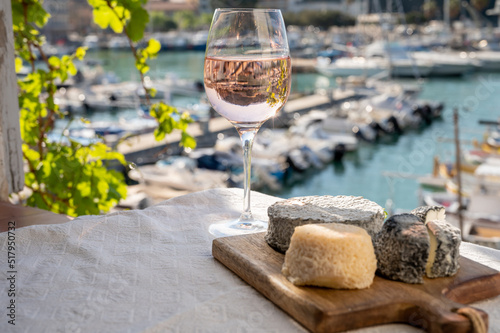 French goat cheeses crottin and selles-sur-cher served with view on boats in harbor of Cassis, Provence, France with glass of dry rose Provencal wine photo