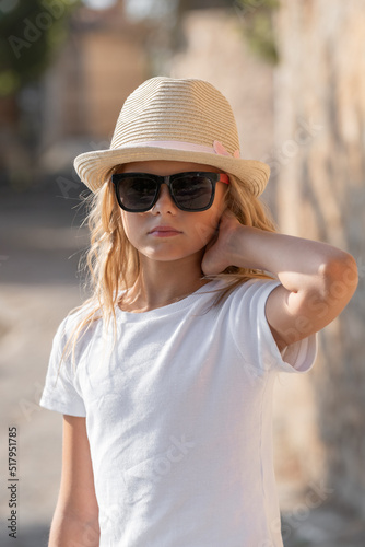 Portrait of a child in a hat and sunglasses in sunny weather.