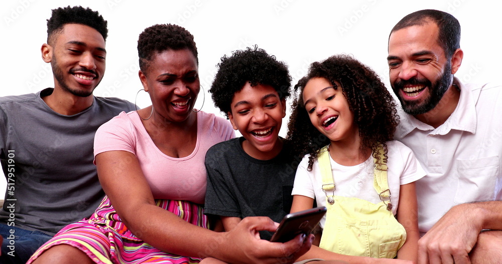Obraz premium Happy mixed race family looking at phone device laughing and smiling