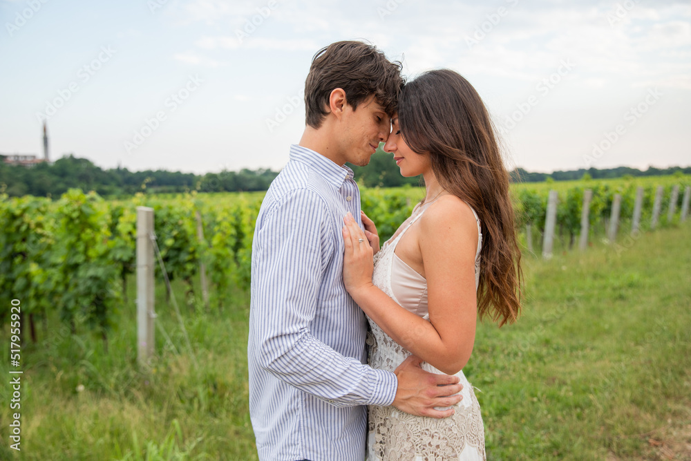 Young couple models huddle nose to nose in a vineyard in the countryside Young couple models huddle nose to nose in a vineyard in the countryside