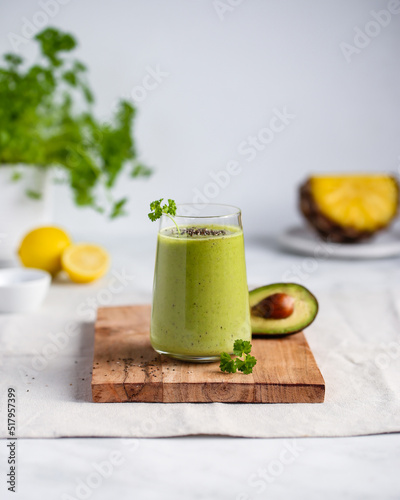 Green smoothie with pineapple, avocado, banana, parsley, lemon juice in a glass, sprinkled with chia seeds. Healthy dieting and nutrition, vegan und vegetarian concept.