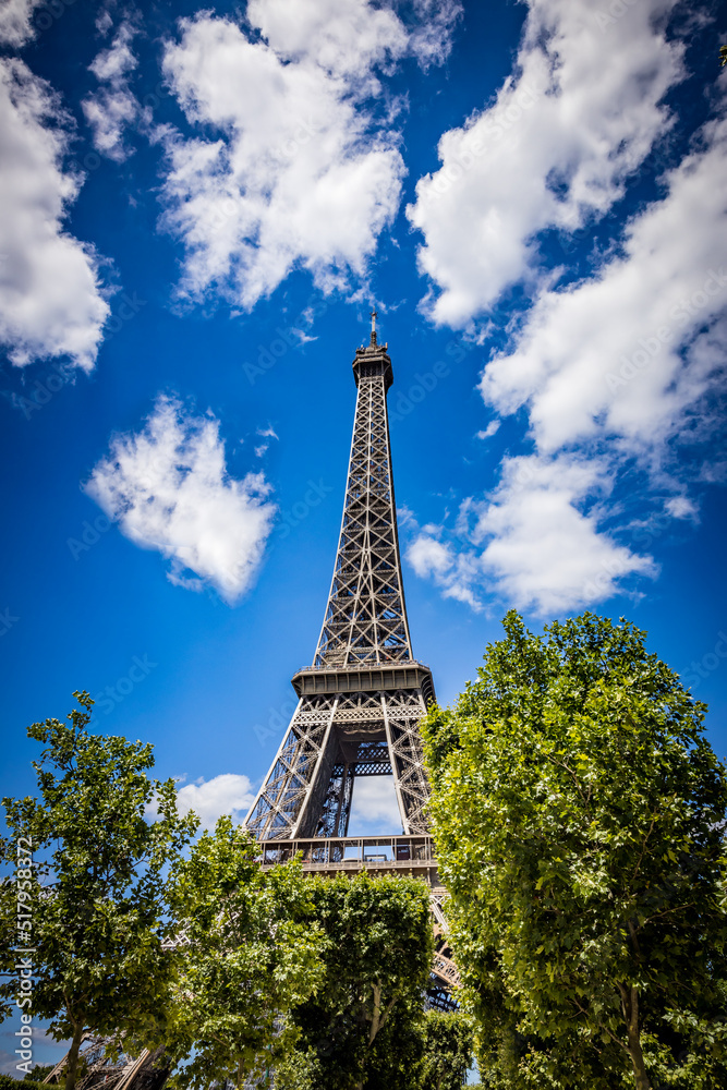 Historic Eifel Tower with sunny blue sky and clouds in summer