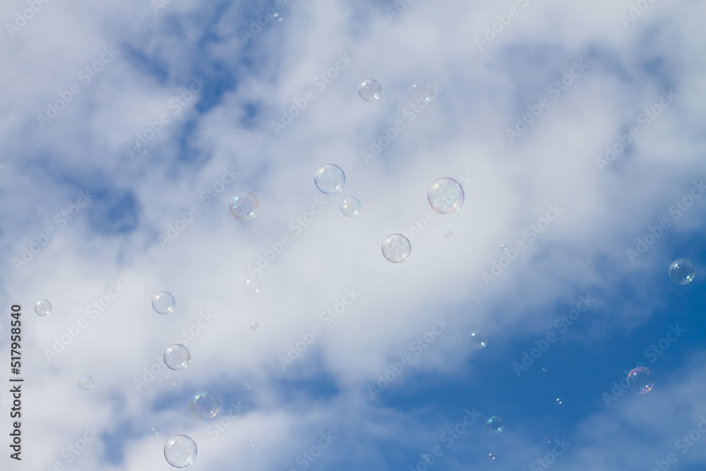 Soap bubbles fly across the blue sky with clouds Soap bubbles fly across the blue sky with clouds