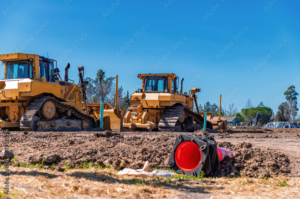 Construction site. A bulldozer and an excavator clear the land for