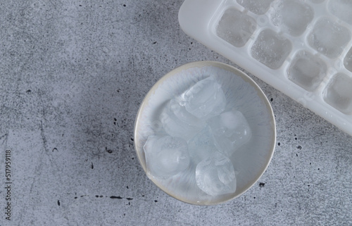 top view of a bowl with ice cubes and the form to make ice cubes in a freezer