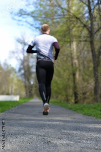 Silhouette of a person running along the path. A man is jogging in the park. Sportswear. Healthy lifestyle.