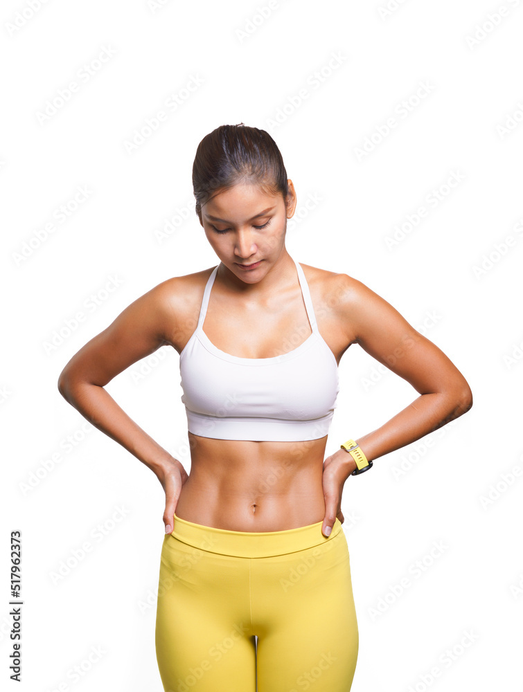 Portrait of Asian sport woman model posing with confidence while looking at the floor with copy space at above her head, image on white background. Healthy girl showing her slim body with tan skin.