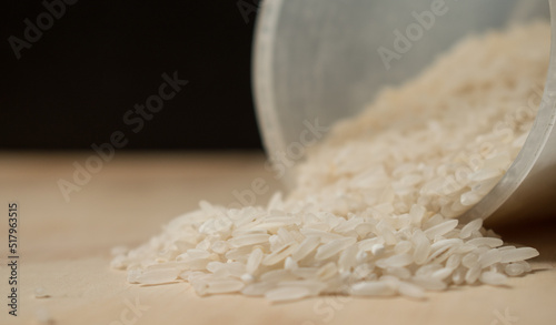 Some white raice grains spiled on a wooden table  photo