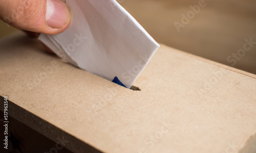Fotografie Hand casting vote in a wooden box