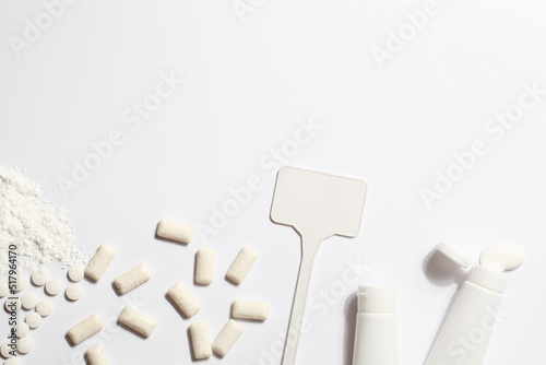 Titanium dioxide, E171, dangerous additive concept. gum, pills, toothpaste, powder and sign with space on white background. copy space photo