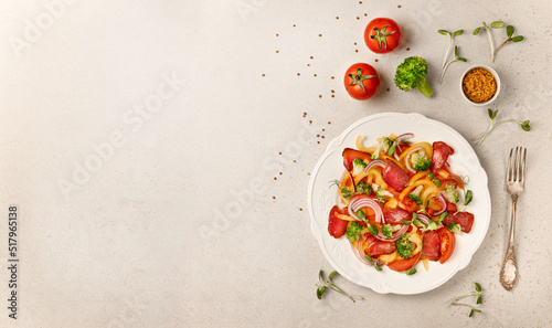 Salad with Prosciutto, tomatoes, onion, sweet pepper and broccoli. Cold snacks. Top view. Free space for your text.