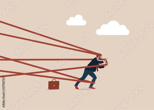 Man tied up with red tape trying to run away with full effort. Business difficulty or struggle with career obstacle, limitation and trap or challenge to overcome to success concept. photo