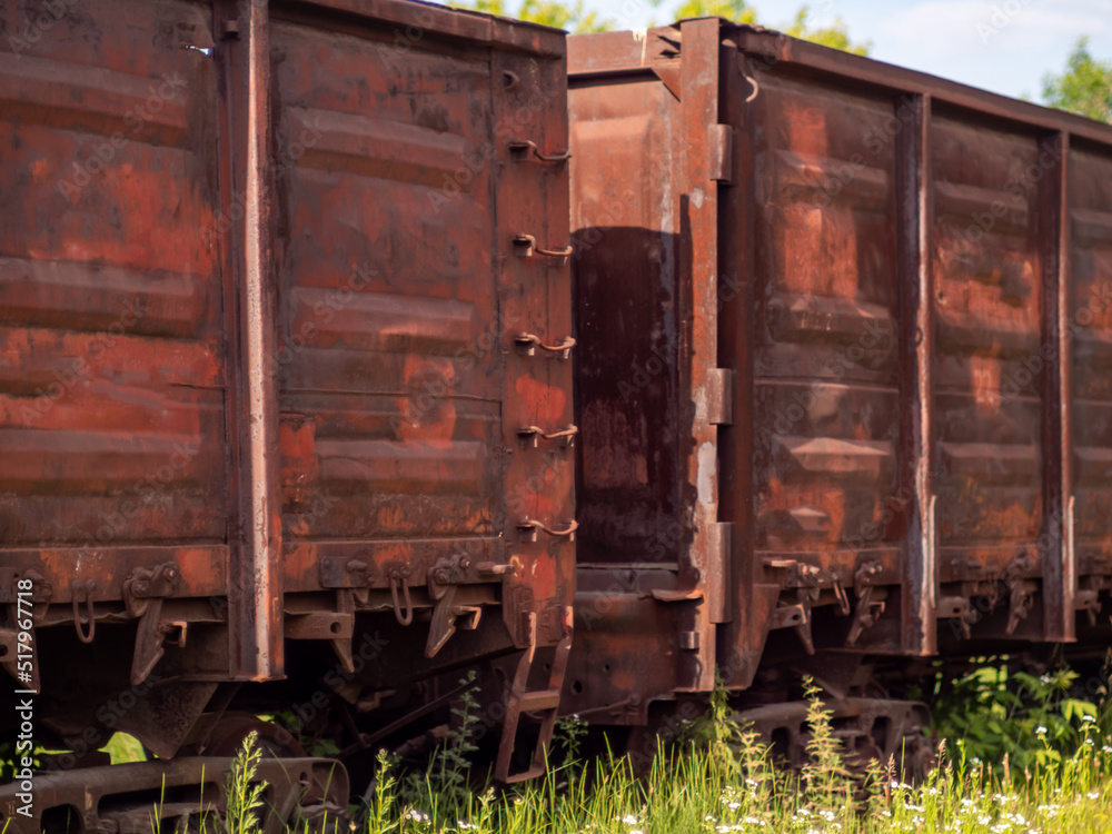 Old rusty railway gondola cars at the marshalling yard. Freight wagons close-up. Transportation of goods over long distances, heavy industry concept Old rusty railway gondola cars at the marshalling yard. Freight wagons close-up. Transportation of goods over long distances, heavy industry concept