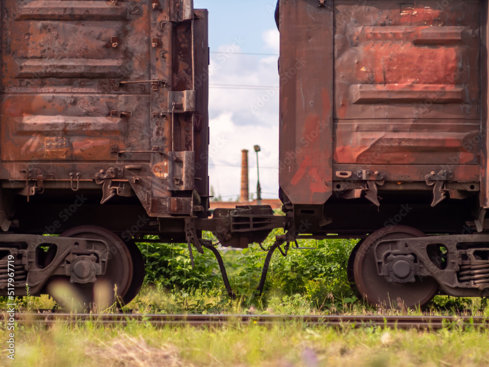 Naklejka premium Old rusty railway gondola cars at the marshalling yard. Freight wagons close-up. Transportation of goods over long distances, heavy industry concept